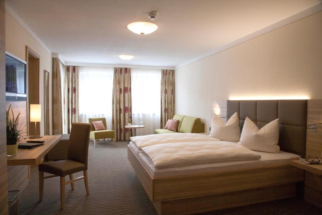 a hotel room with a bed and a desk at Hotel Straßhof in Pfaffenhofen an der Ilm