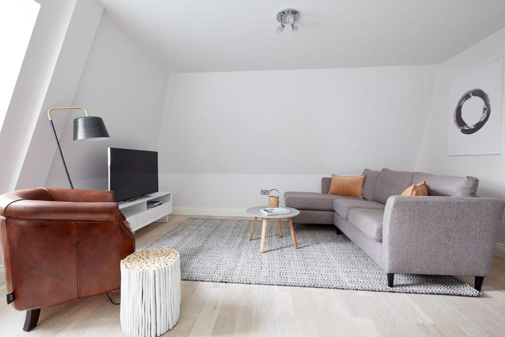 a living room with a couch and a chair at 7VH Virginia House, 31 Bloomsbury Way By City Living London in London