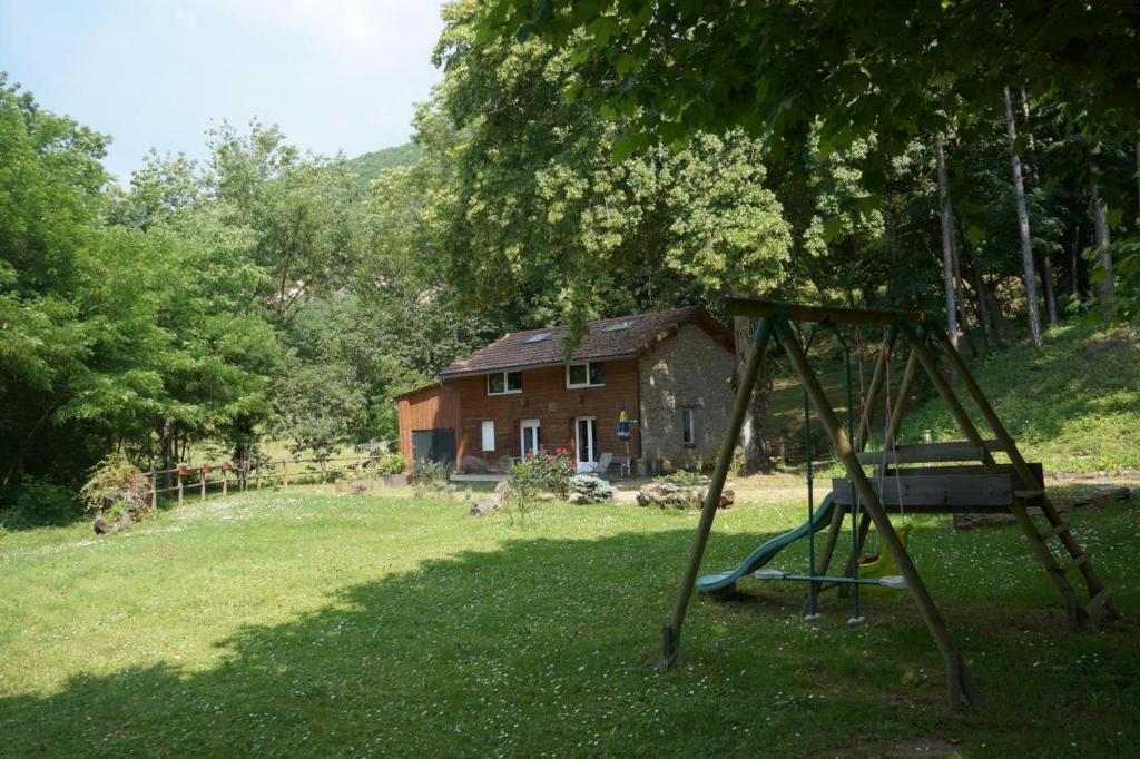 a swing set in a yard in front of a house at A l'oree du bois - Gite in Hostun