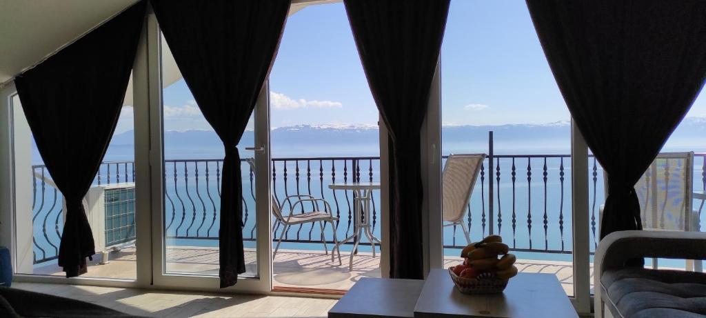 een kamer met een balkon met uitzicht op de oceaan bij Digital Nomad Villa EROS in Struga