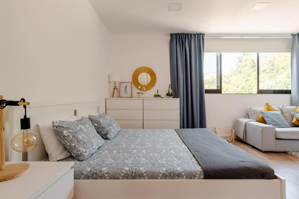 um quarto com uma cama e um sofá em Stylish and Elegant Studio - Best View and Location in Coimbra Downton em Coimbra