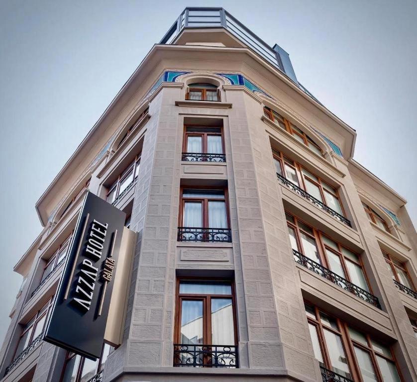 a tall building with windows and a traffic light at Azzap Hotel Galata in Istanbul