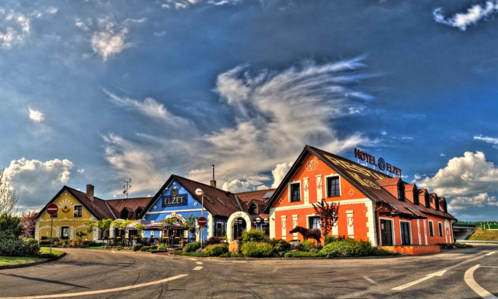 eine Reihe von Häusern auf einer Straße mit wolkigem Himmel in der Unterkunft Hotel Elzet in Tábor