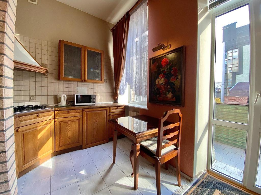 a kitchen with a table and a chair in it at Apartment with city history in the center in Dnipro
