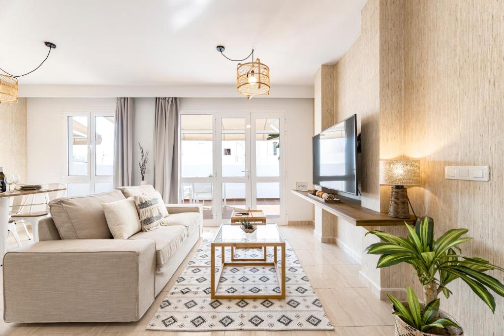 a living room with a couch and a tv at Apartments Urban Arrecife in Arrecife