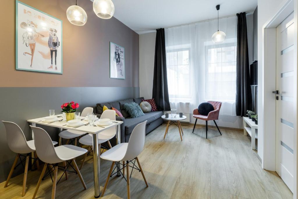 Friendhouse Residence في كراكوف: غرفة معيشة مع طاولة وأريكة زرقاء