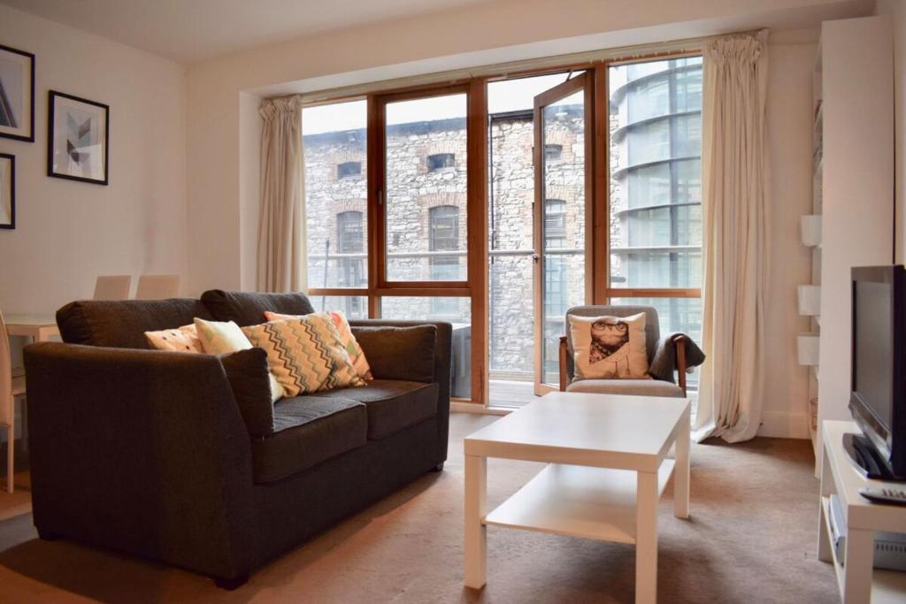 een woonkamer met een bank en een stoel bij Modern and stylish apartment by Grand Canal in Dublin