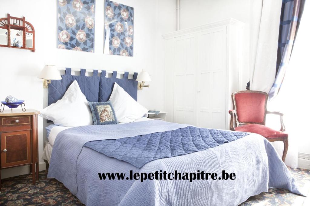 een slaapkamer met een bed met een blauw dekbed en een stoel bij " Chimay B & B " - ptits déj gourmands proposés in Chimay