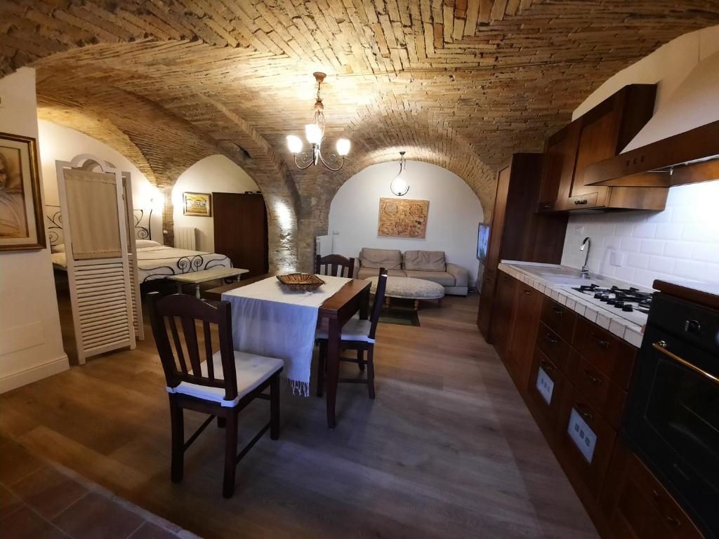 uma cozinha e sala de jantar com uma mesa e um sofá em Dimora Porta Venere em Spello
