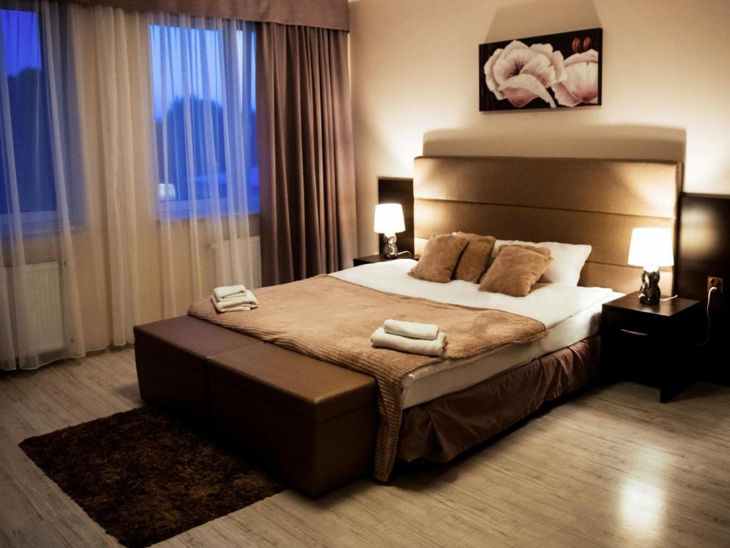 een slaapkamer met een groot bed en 2 handdoeken bij Hotel Feniks in Gniezno
