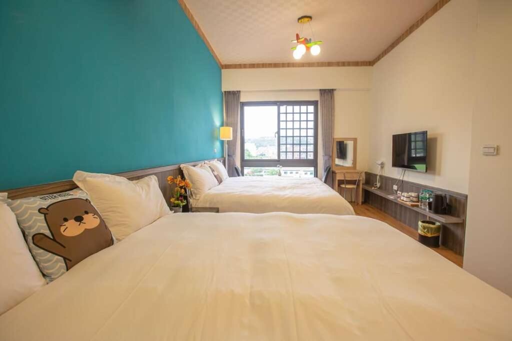 a hotel room with two beds and a television at Otter Hotel in Jinhu