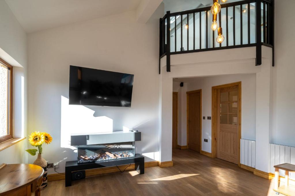 ein Wohnzimmer mit weißen Wänden und einem Flachbild-TV in der Unterkunft Loaf Tin in Kendal