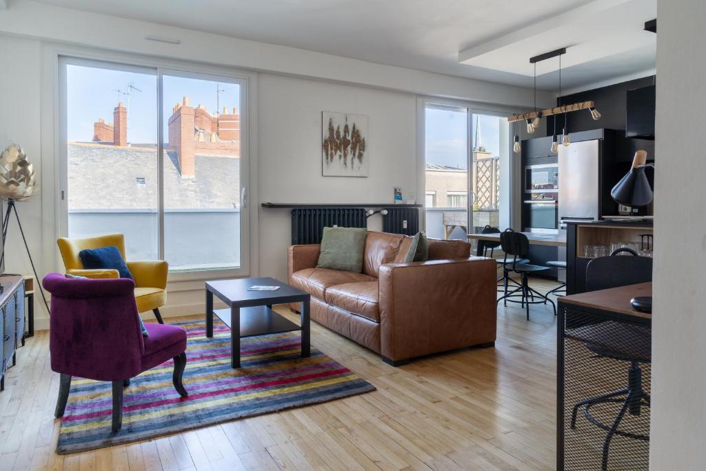 un salon avec un canapé et des chaises dans l'établissement Le Manège - Spacieux T2 avec Terrasse au coeur de Nantes, à Nantes