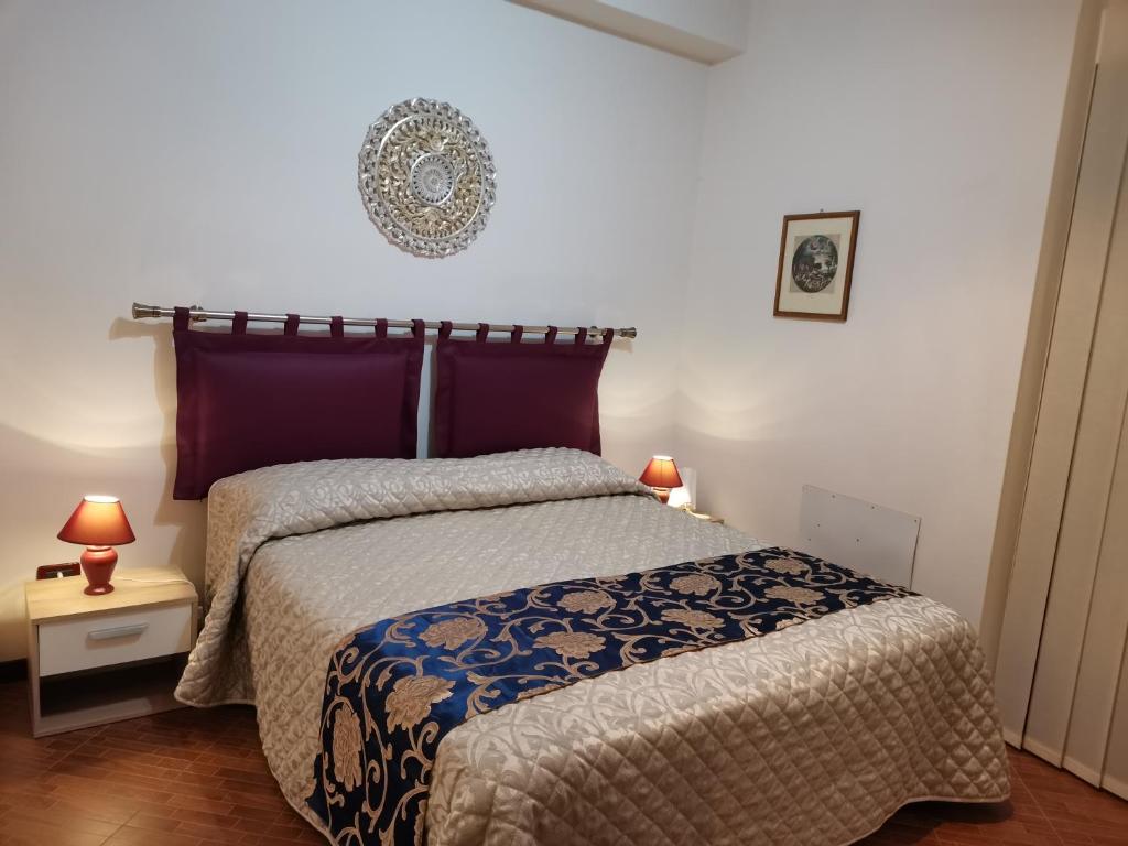 1 dormitorio con 1 cama con edredón y 2 lámparas en SEGESTA - New Nouveau Bedding, en Salemi