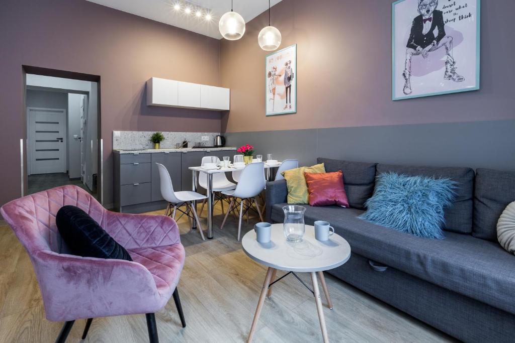 - un salon avec un canapé, des chaises et une table dans l'établissement Kazimierz Friendhouse Apartments, à Cracovie