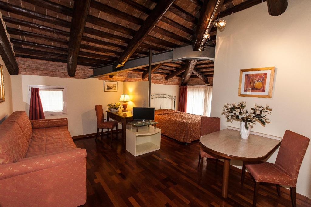 a living room with a bed and a desk with a computer at Residence Bertolini in Padova