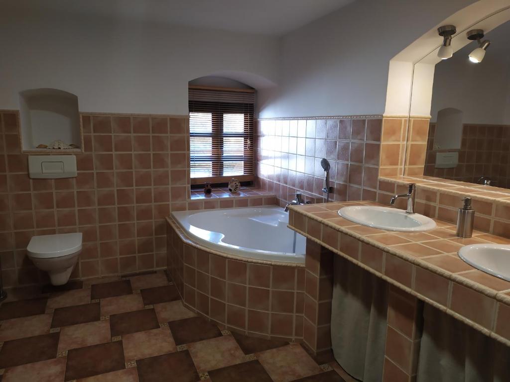 łazienka z 2 umywalkami, wanną i toaletą w obiekcie Forest Rustic Apartment Brdy w mieście Buková
