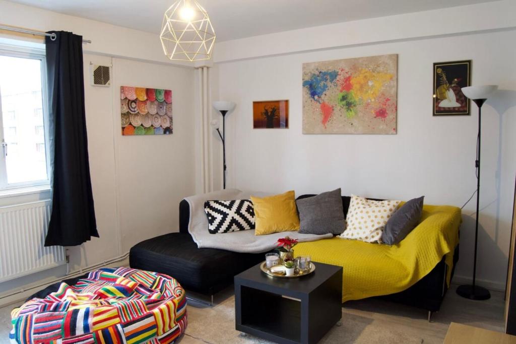 a living room with a yellow couch and a chair at Modern 1 Bedroom in Shadwell with Balcony in London