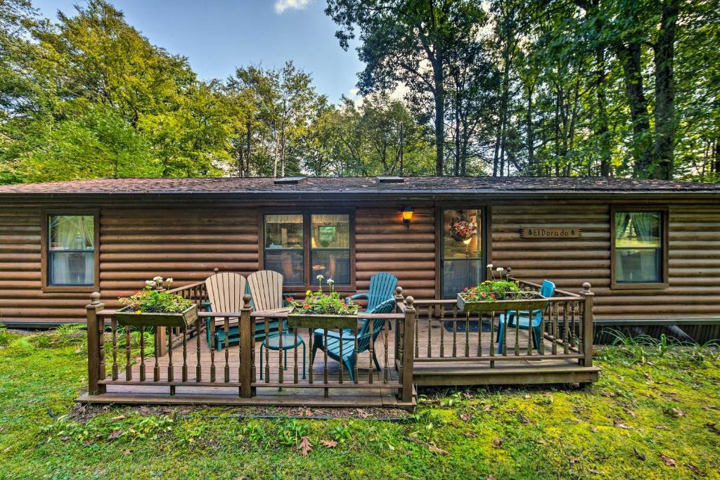 a cabin with a deck with chairs and a table at Scenic Spring Mills Escape Swim, Fish, Hike! in Spring Mills