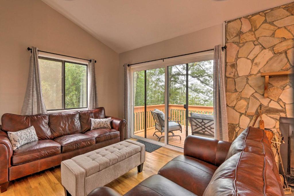 una sala de estar con muebles de cuero y una gran pared de piedra. en Blue Ridge Acres, Riverfront Home with Deck, en Harpers Ferry