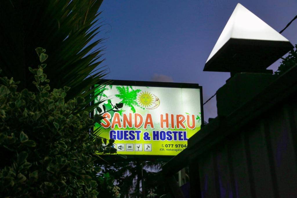 una señal para un restaurante en la parte superior de un edificio en Sanda Hiru Guest, en Mirissa