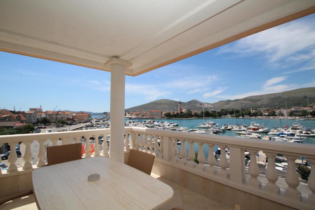 a balcony with a table and a view of a marina at Hotel Trogir Palace in Trogir