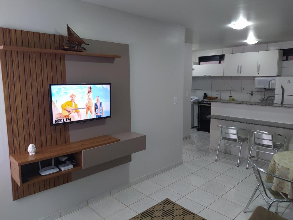 sala de estar con TV de pantalla plana en la pared en Apartamento na orla de Maceió en Maceió