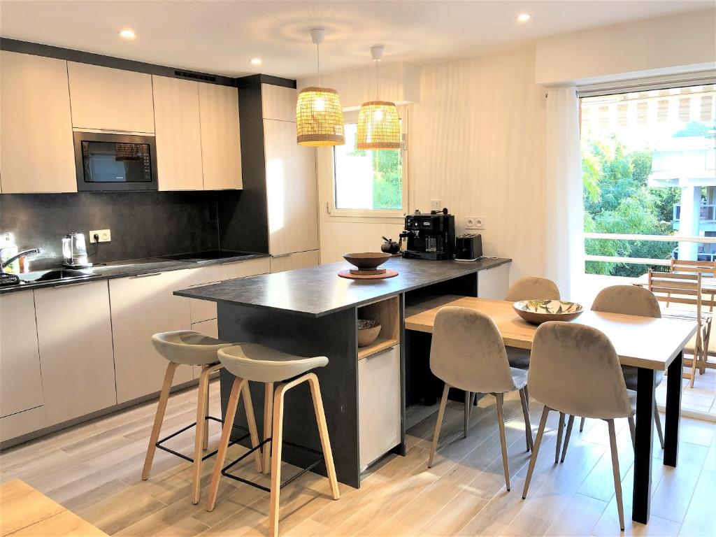 - une cuisine avec une table, des chaises, une table et un comptoir dans l'établissement LOUISIANE T2 moderne proche plage parking wifi, à Arcachon