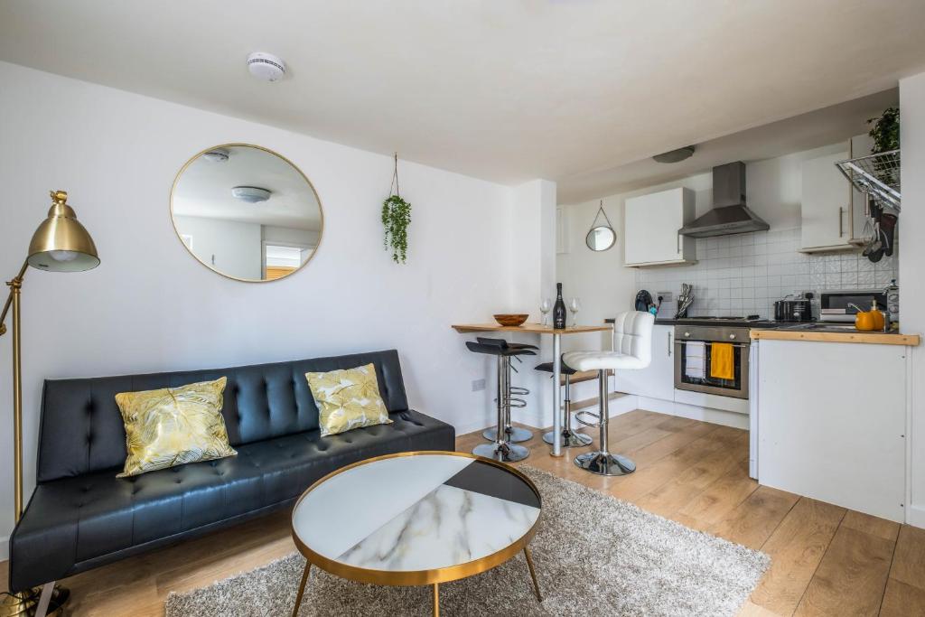 - un salon avec un canapé noir et une table dans l'établissement Cosy flat in Free Parking Area, Next to Bus Stop, à Brighton et Hove