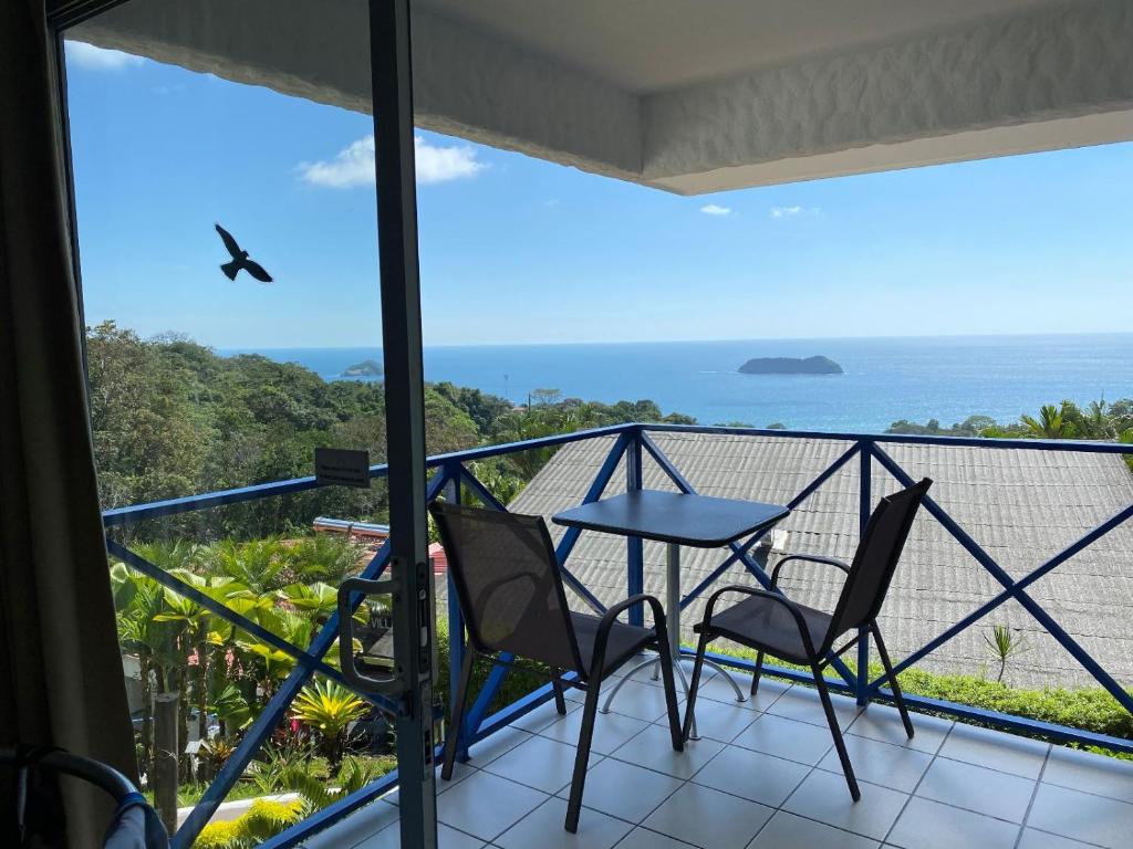 a balcony with a table and chairs and the ocean at Villa Roca Boutique Resort & Suites - ADULT ONLY in Manuel Antonio