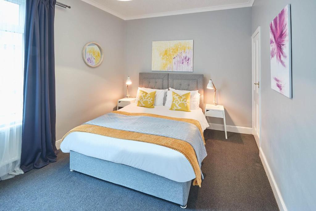 a bedroom with a large bed with yellow pillows at Eskdale House by Horizon Stays in Darlington