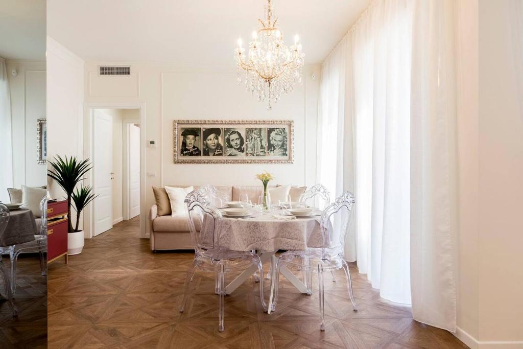 una sala da pranzo con tavolo, sedie e lampadario pendente di Madonna Montecchi Luxury Suite in Verona a Verona