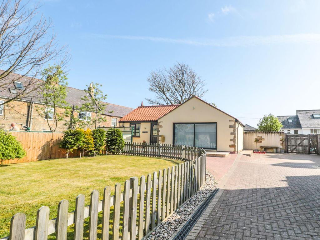 a fence in front of a house with a yard at 3 The Paddock in Chathill