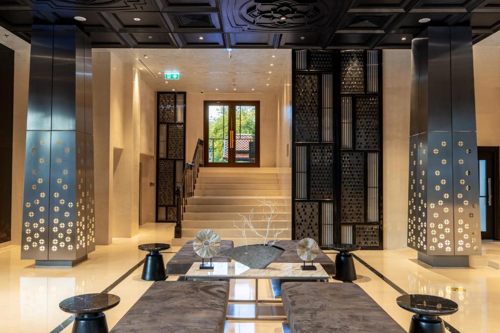 A richly decorated lobby entrance with a staircase and reception seating.