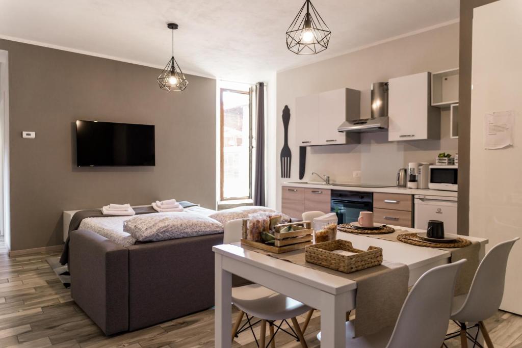 una cucina e un soggiorno con letto e tavolo di Via Mazzini B & B (MXP) a Vizzola Ticino