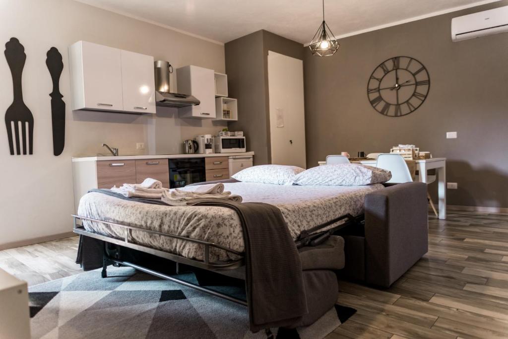 una camera con un grande letto e una cucina di Via Mazzini B & B (MXP) a Vizzola Ticino