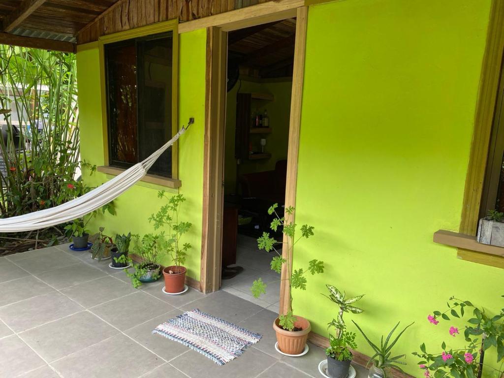 
a green room with a green wall and a blue door at Bungalows Kire in Puerto Viejo
