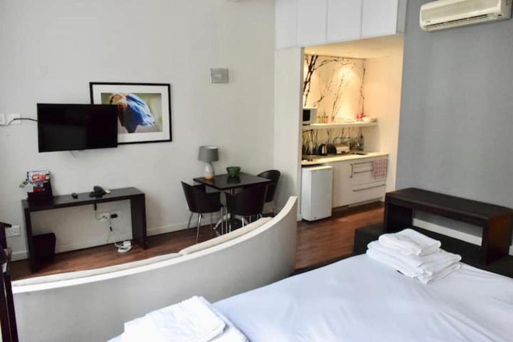 um quarto com uma cama e uma cozinha com uma mesa em 1 Bedroom Apartment with Roof Top Views em Cidade do Cabo