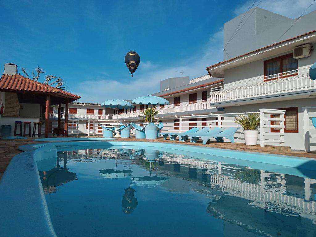 a hot air balloon flying over a hotel pool at Pousada Caminho do Mar in Torres