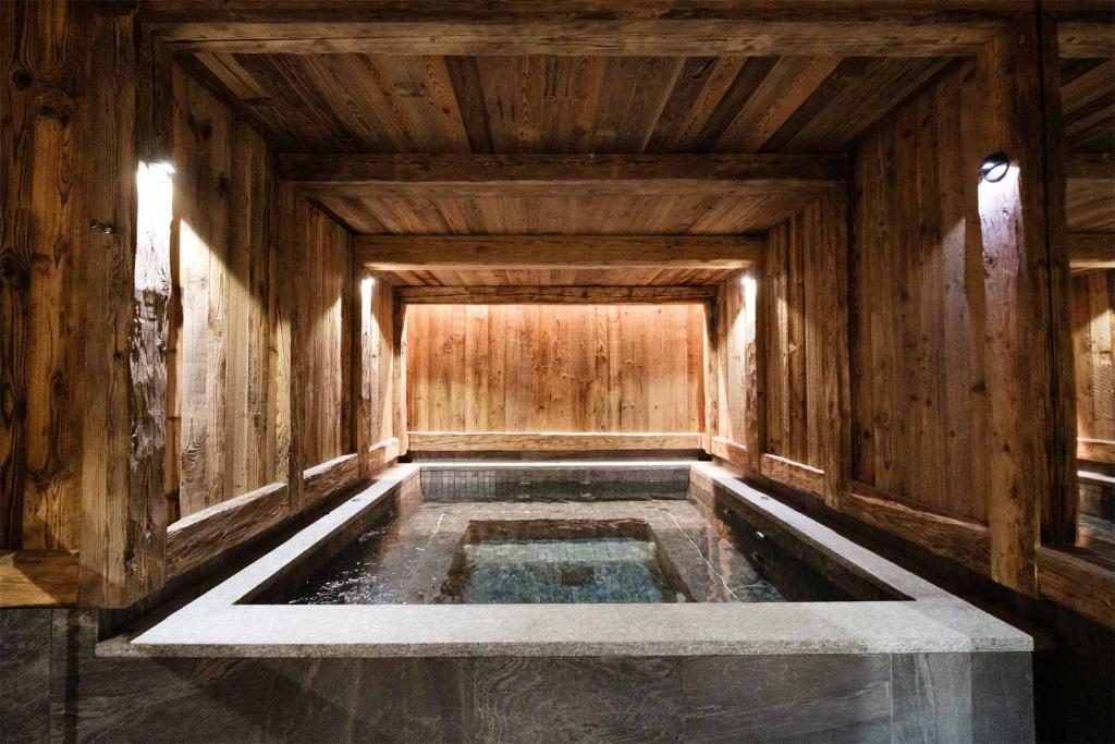 einen Wasserpool in einem Zimmer mit Holzwänden in der Unterkunft Madame Vacances Chalet Inuit in Val dʼIsère