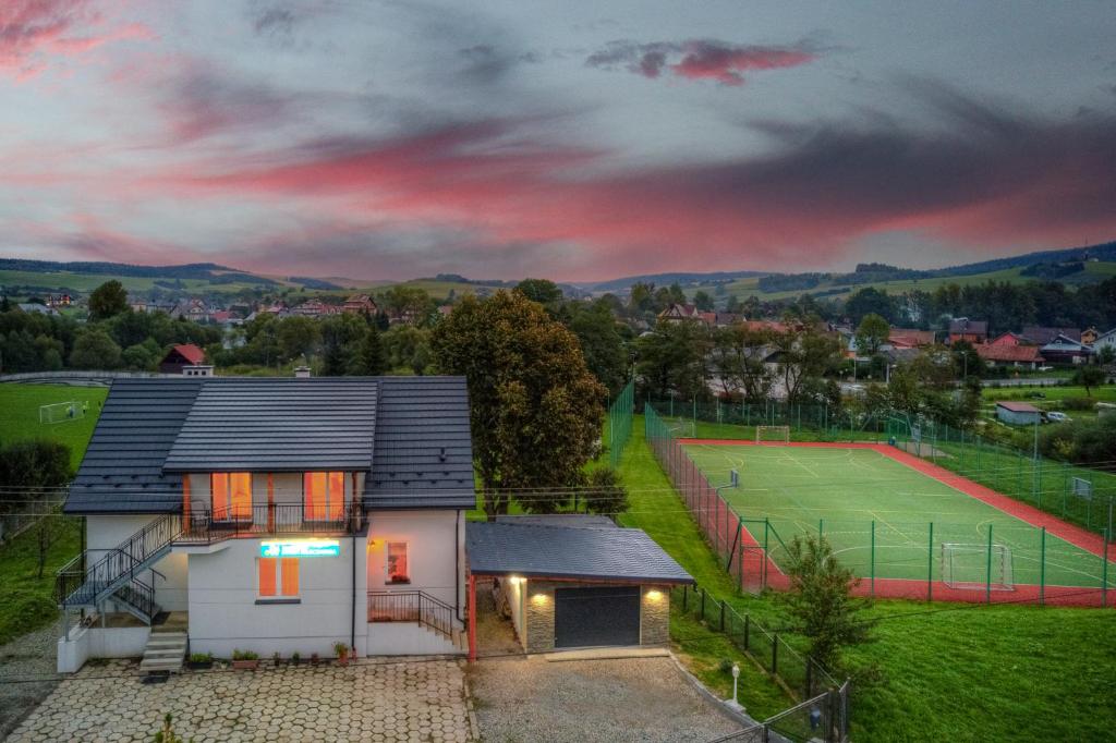 a house with a tennis court in front of it at Stara Mleczarnia in Tylicz