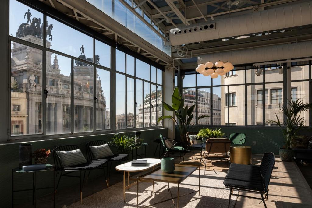 a large room with chairs and tables and windows at Petit Palace Alcalá in Madrid