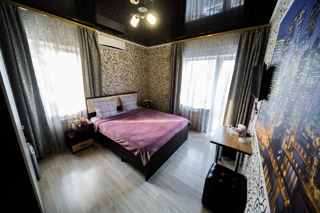 ロストフ・ナ・ドヌにあるマレラ ホテルの小さなベッドルーム(紫色のベッド1台、窓付)