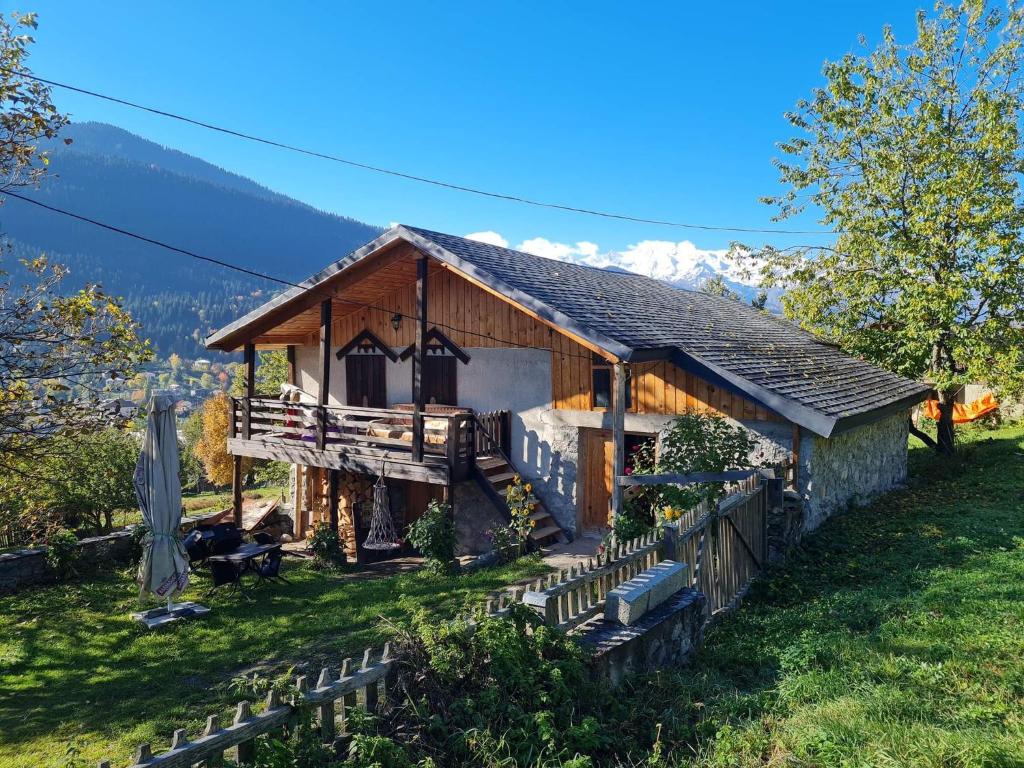 a house on a hill with mountains in the background at Nadia Guesthouse in Mestia