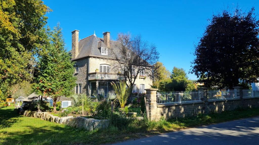 una casa vieja con una valla delante de ella en La Villa Saint Martin en Cournon