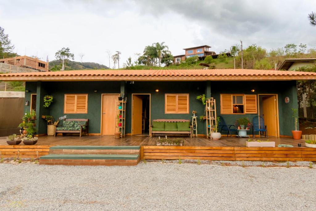 a house with a wooden deck in front of it at Vila do Lago in São Bento do Sapucaí