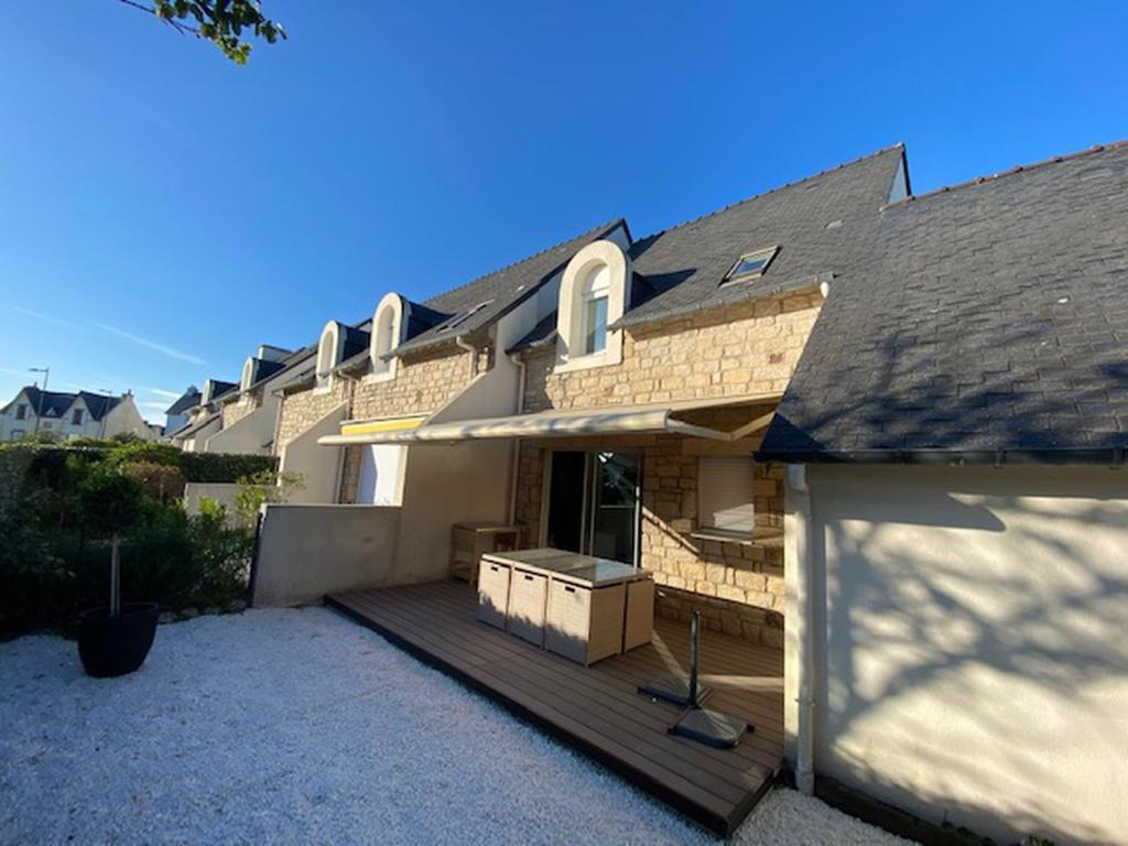 une maison avec une terrasse en bois devant elle dans l'établissement Maison-villa Quiberon, 5 personnes, jardin, proche du port, plages baie et océan, à Quiberon