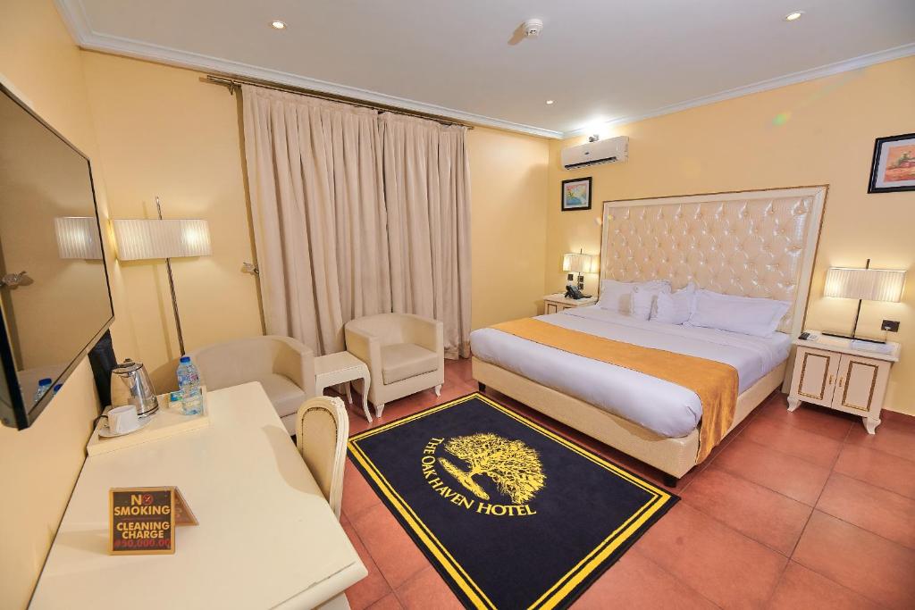 una camera d'albergo con letto king-size e divano di Oak Haven Hotel & Suites a Port Harcourt