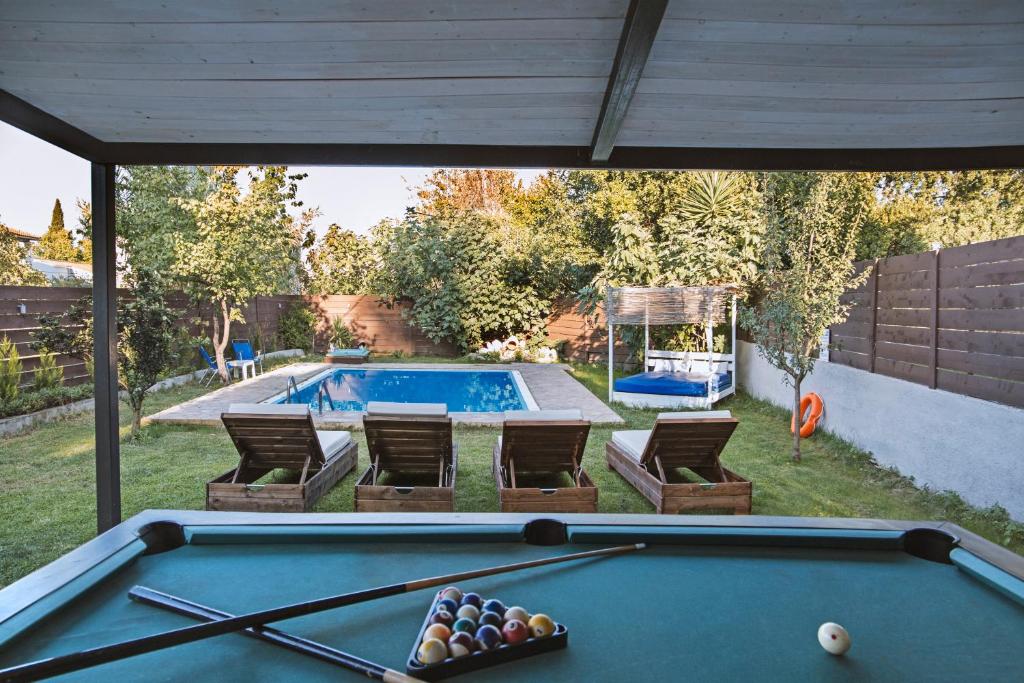 a pool table in a backyard with a swimming pool at Villa Hermes in Potamós