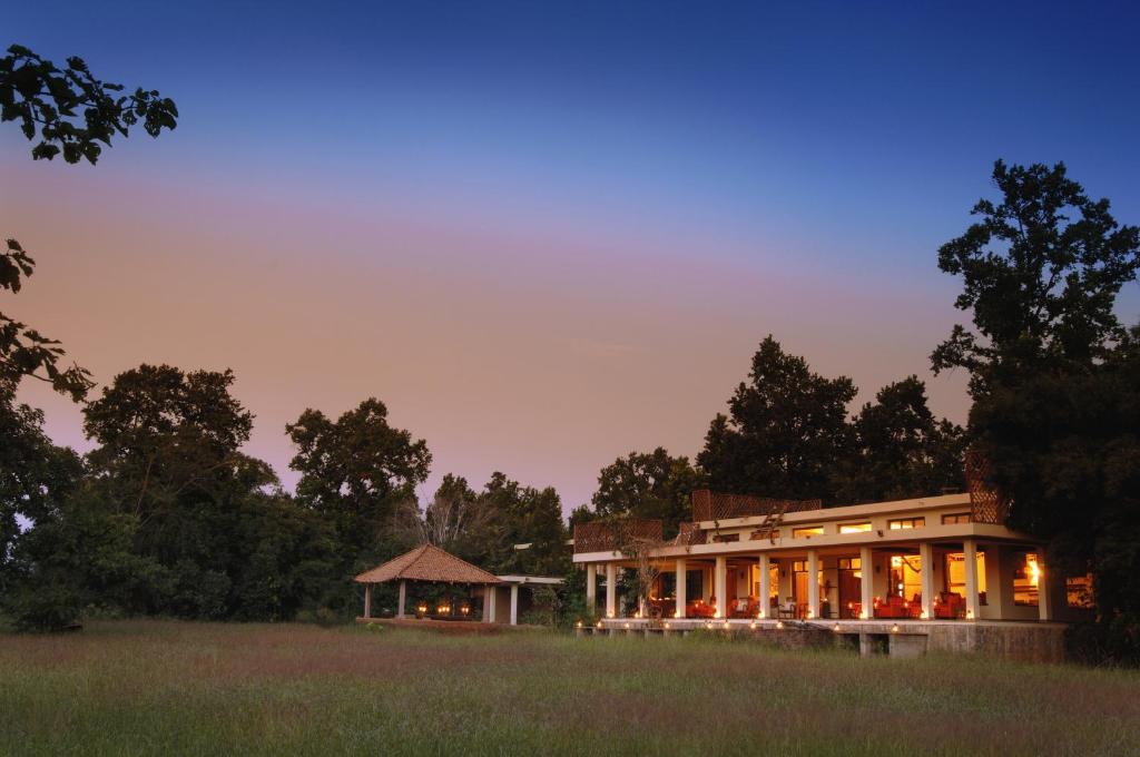 un grand bâtiment avec un kiosque dans un champ dans l'établissement Mahua Kothi Bandhavgarh - A Taj Safari Lodge, à Tāla